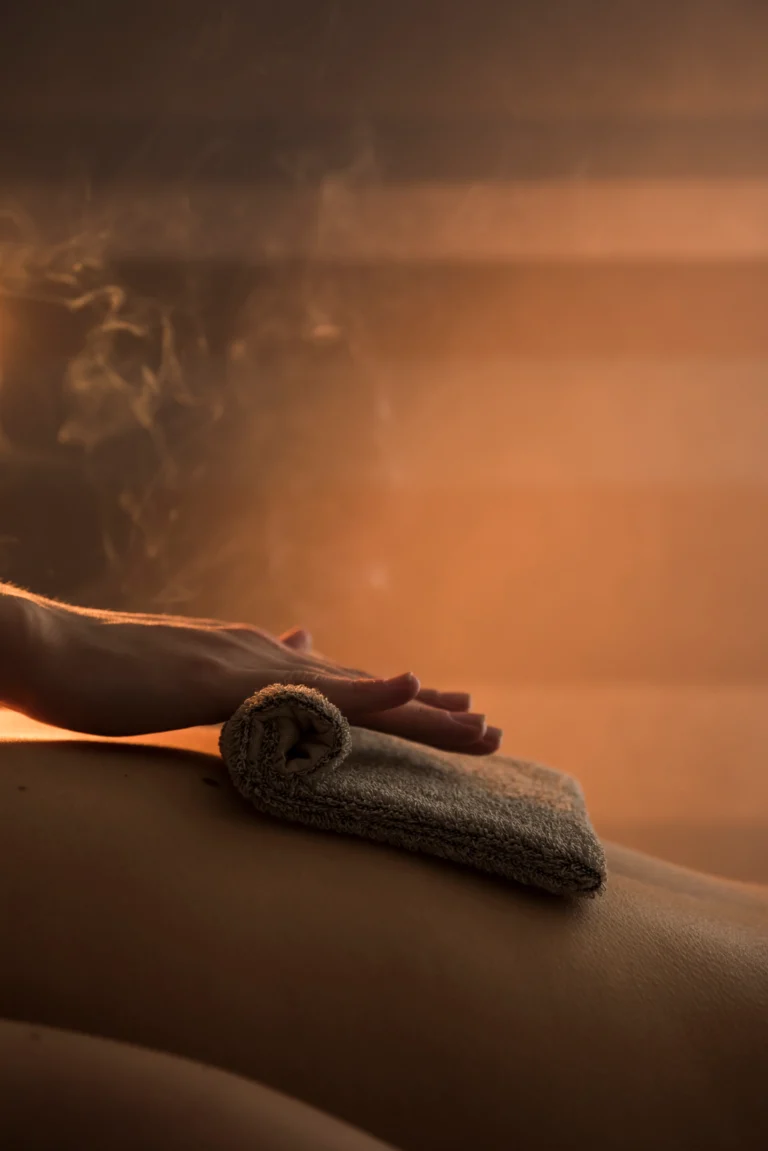 close-up-therapist-hand-massaging-woman-s-back-with-hot-towel-spa